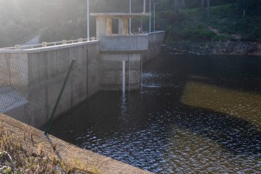 The rio da mula dam regulating the water levels for the surrounding area in the serra de sintra region of portugal clipart