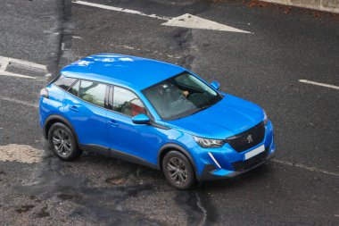 Asfalt yolda giden mavi peugeot 2008 SUV