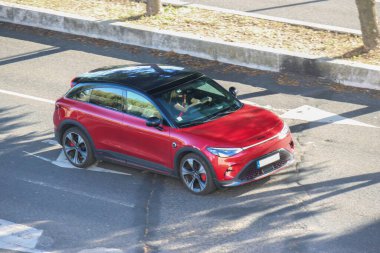 Şehir yolunda giden kırmızı akıllı 3 elektrikli araba, şehir ulaşımının geleceğine göz atmamızı sağlıyor.