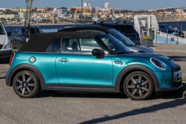 Turkuaz mini Cabrio Sahil Baskısı Lizbon, Portekiz 'deki Tejo nehrinin yanındaki otoparka park edilmiş.