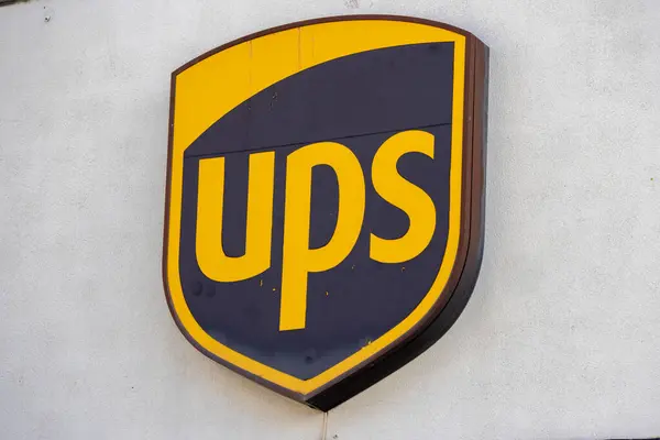Ups logosu küresel nakliye ve dağıtım hizmetlerini temsil eden bir binanın ön cephesinde sergileniyor