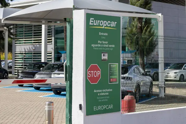 Europcar araba kiralama otoparkı dur levhası, bariyer kapısı ve araçlar için özel erişim olduğunu gösteren tabela ile giriş kontrolünü gösteriyor.