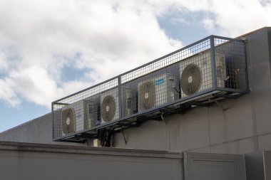 Binanın dış duvarına koruyucu metal bir kafesin içine yerleştirilmiş birkaç havalandırma ünitesi var.