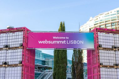 Entrance to web summit lisbon, portugal, decorated with stacks of ibc tanks and a welcome banner clipart