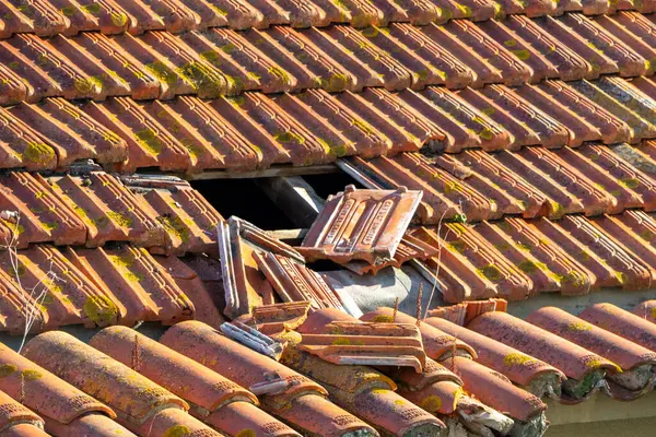 Kırık kil kiremitli hasarlı çatı ve acilen onarılması gereken görünür döşemeler.