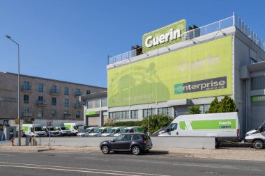 Lizbon, Portekiz 'de güneşli bir günde park etmiş araçları olan Guerin araba kiralama acentesinin modern binası.