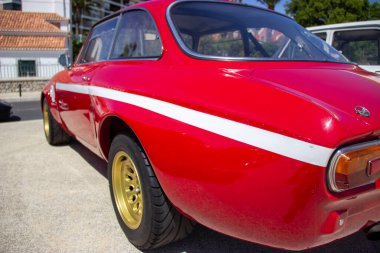 Parlak kırmızı alfa romeo gta 1300 Junior güneşli bir günde park etmiş.