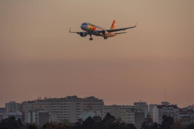 Tap Air Portekiz uçağı gün batımında iniş takımlarıyla Lizbon havaalanına yaklaşıyor.