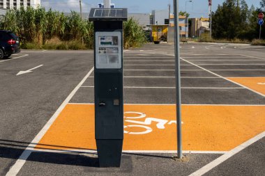 Engelliler için ayrılmış bir park yerinde güneş paneli olan parkmetre