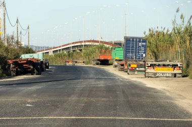 Otoyol üst geçidinde boş duran çeşitli tırlar, nakliye lojistiğinde bir duraklama olduğunu gösteriyor.