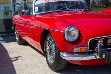 Gleaming red mg b vintage roadster parked, showcasing its classic british design and chrome details clipart