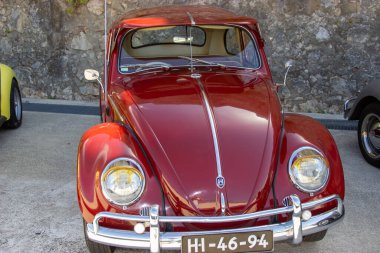 Klasik kırmızı Volkswagen böceği park etmiş, klasik cazibesini ve zamansız tasarımını sergiliyor.