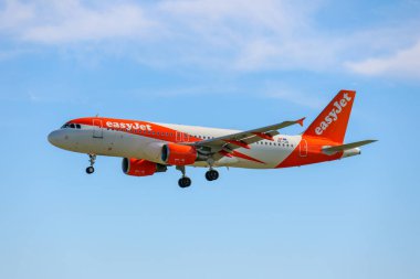 Orange and white easyjet airbus a320 landing at lisbon humberto delgado international airport clipart