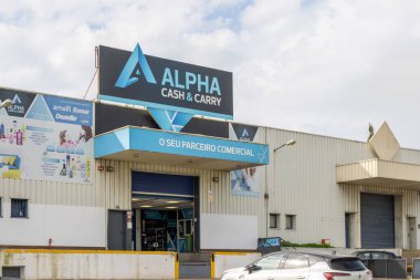 Günümüz alfa nakitleri ve toptan satış mağazası binaları güneşli bir günde tabelalı ve park halindeki arabalarla.