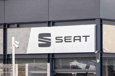 Modern seat car dealership building showcasing prominent logo signage and security cameras clipart