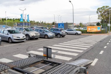 Boş araba nakliye karavanı asfalt bir otoparka park edilmiş yaya geçidi ve park edilmiş arabalar.