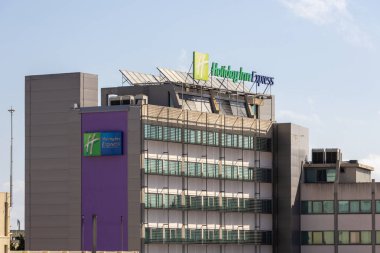 Tanınmış tatil oteli ekspres markalaşma ve çatı güneş panelleri ile modern otel binası, konukseverlik sektöründe sürdürülebilir uygulamaları gösteriyor