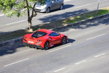 Kırmızı ferrari f8, çok şeritli bir yolda araba kullanmanın koludur.