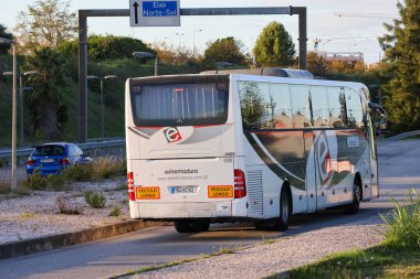 Portekiz 'in kuzey güney ekseni yol tabelasından uzaklaşan beyaz ve siyah tur otobüsü.