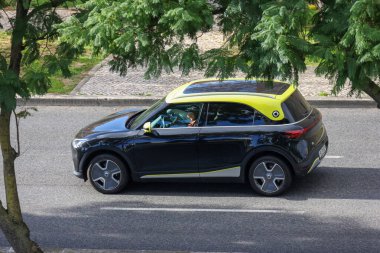 Şehir sokaklarında gezen, modern bir şehir ortamında sürdürülebilir ulaşım gösteren şık elektrikli araç.