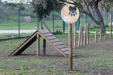 Wooden agility equipment stands ready for canine fun at a dedicated dog park in loures, portugal, promoting pet exercise and socialization clipart