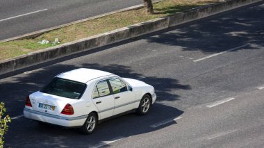 White mercedes c class w202 driving on asphalt road