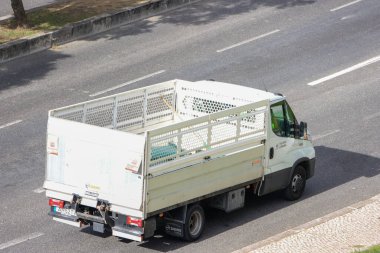 Beyaz fildişi günlük taksi şasi kamyonu çok şeritli bir yolda gidiyor.