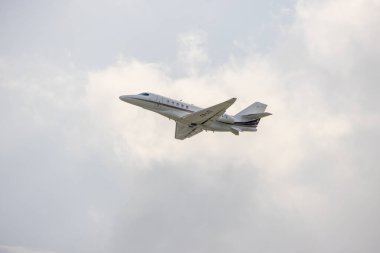 Lizbon havaalanından havalandıktan sonra bulutlu gökyüzüne çıkan beyaz özel jet.