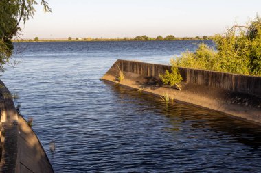Tagus nehrinin sakin suları günbatımında yavaşça beton bir kanala akar ve Portekiz 'de sakin bir manzara yaratır.