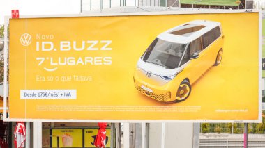 Yeni Volkswagen kimliğini tanıtan sarı ilan panosu. Buzz elektrikli minivan, 7 koltuk kapasitesini vurguluyor