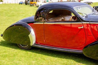 Classic delahaye 135m competition coupe parked on grass, showcasing its luxurious design and two tone paint job clipart