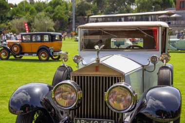 Parlayan beyaz rulolar Royce prestijli bir klasik araba gösterisinde sahneye çıkıyor, zamansız tasarımını ve lüks detaylarını sergiliyor.