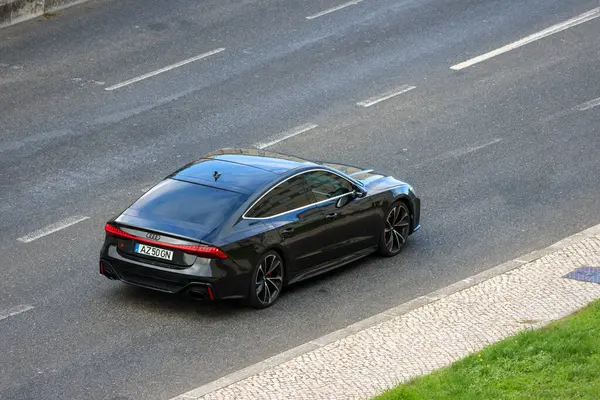 Siyah Audi Rs7 spor arabası asfalt yolda sürüyor.