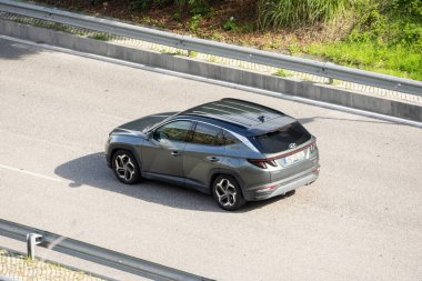 Modern SUV Hyundai Tucson güneşli bir günde otobanda araba sürüyor.
