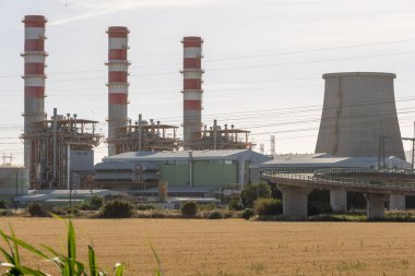 Ribatejo power station generating electricity with large cooling towers and chimneys on a sunny day clipart