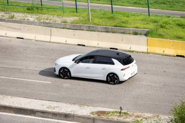 Modern beyaz opel astra otoyolda ilerliyor.