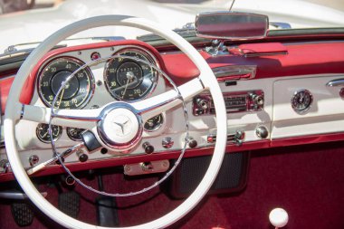 Klasik bir Mercedes Benz 190sl 'in zarif iç mekânını kapatın, beyaz direksiyon, gösterge paneli ve göstergeler