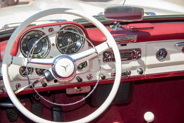 Klasik bir Mercedes Benz 190sl 'in zarif iç mekânını kapatın, beyaz direksiyon, gösterge paneli ve göstergeler