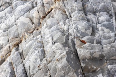 Sert dokular ve jeolojik desenler Sintra, Portekiz 'deki Adraga Sahili' nin kayalık uçurumlarında büyüleyici bir görüntü oluşturur.