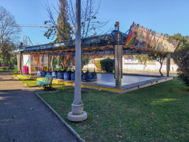 Renkli tasarımla kaplı atlı karınca eğlence parkında boş duruyor, parlak, güneşli bir günde çocukların kahkahalarını ve heyecanını bekliyor.