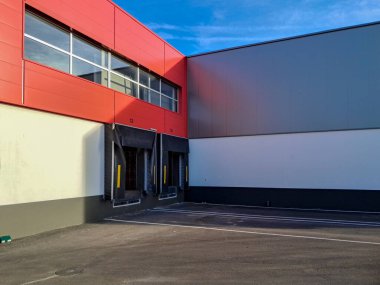 Kırmızı ve gri renkleri yansıtan modern bir dağıtım deposunun rıhtımları yükleniyor