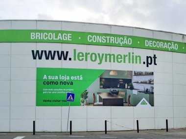 Portekiz 'deki bir Leroy Merlin mağazasının ön cephesinde büyük bir reklam var. Ev geliştirme projeleri için hizmetlerini ve web sitelerini sergiliyorlar.