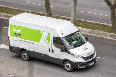 Yollarda Guerin Holding araba kiralama şirketi logosuyla markalı beyaz bir karavan.