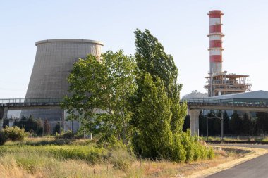 Ribatejo elektrik santrali soğutma kulesi ve bacasıyla bir yol ve köprü yakınında elektrik üretiyor.