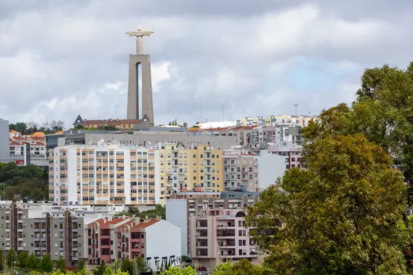 Cristo Rei heykeli, bulutlu gökyüzünün, Lizbon metropolitan bölgesinin, Portekiz 'in bulutlu şehrinin üzerinde dimdik duruyor.