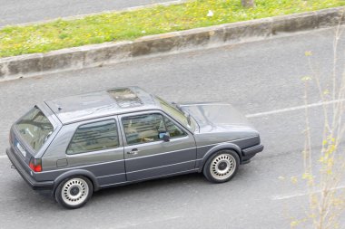 Eski model gri Volkswagen golf mk2 arabası yolda gidiyor.
