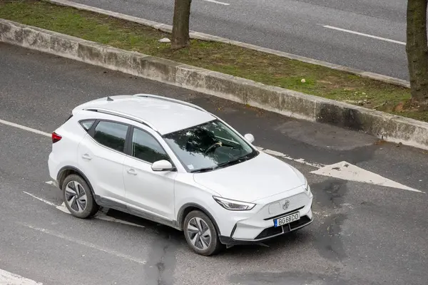 Şehir yolunda sürmekte olan modern elektrikli araç, sürdürülebilir ulaşımı sergiliyor