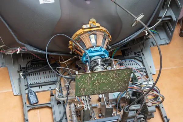 Parçalanmış bir crt televizyonun iç bileşenlerini kapat, kablolar, devreler ve elektronik parçalardan oluşan karmaşık ağı ortaya çıkar.