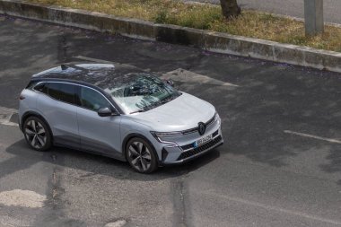 Asfalt yolda giden modern elektrikli araba, yukarıdan görülüyor.