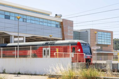 Portekiz demiryolu şirketinin modern kırmızı treni Castanheira do ribatejo istasyonunda duruyor.
